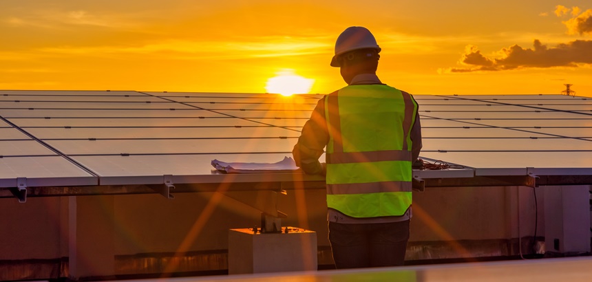 Homem instalando energia solar em uma indústria